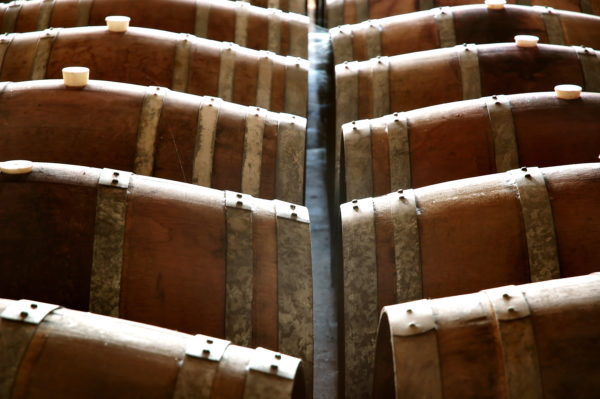 Wine barrel in a winery cellar featuring vats and casks in the background. Similar to Barossa Valley and Clare Valley styles